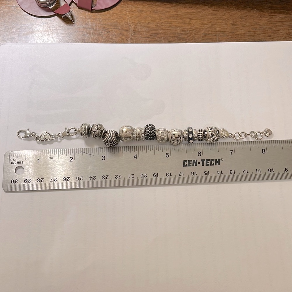 Brighton bracelet with 11 charms.  Silver and black accented charms